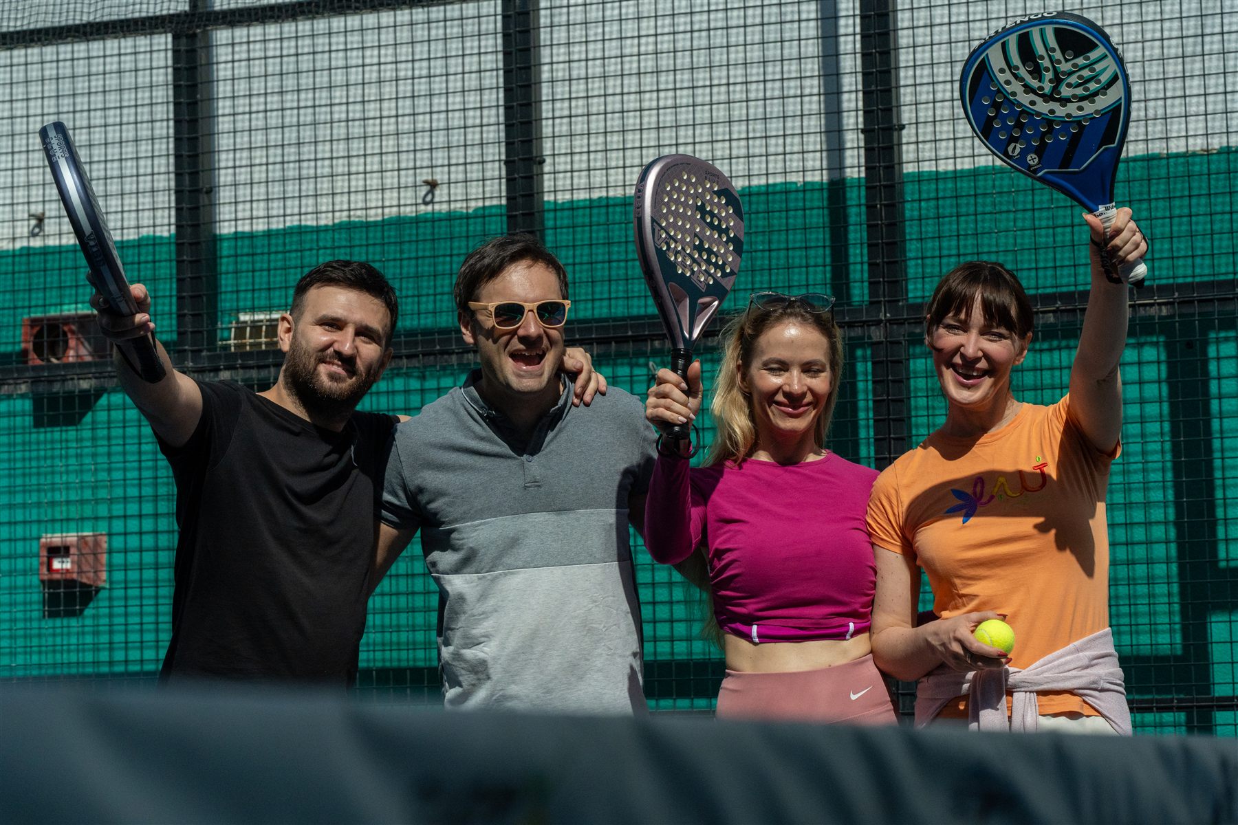 A small padel group smiling on court in Cyprus